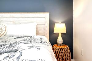 Un dormitorio con una cama y una lámpara sobre una mesa. en Sandy Pearl Lake View 3 Pools Central Destin, en Destin