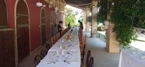 a long row of tables with plates and wine glasses at La Regina del Bosco in Rivignano