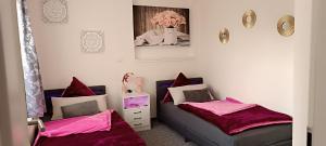 2 Betten in einem Zimmer mit rosa Bettwäsche in der Unterkunft Ferienwohnungen Auetal in Kucksdorf