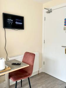 a room with a table and a television on the wall at Edinburgh full house in Edinburgh