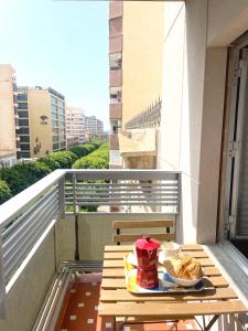 a table with a plate of food on a balcony at AT Paseo Ficus Centenario in Almería