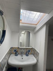 un baño con lavabo y espejo en Delizioso Monolocale mansardato, en Viareggio
