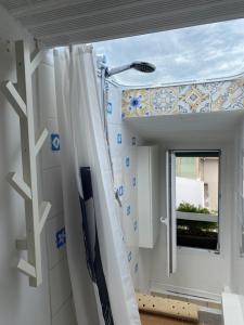 baño con cortina de ducha y ventana en Delizioso Monolocale mansardato, en Viareggio