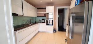 a kitchen with white cabinets and a stainless steel refrigerator at Résidence MontBlanc duplex avec jacuzzi in Geneva