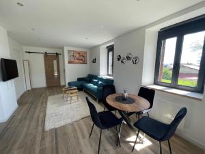 a living room with a couch and a table and chairs at Le petit jurassien 2 in Bellefontaine