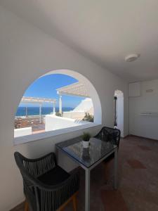 a dining room with a table and a view of the ocean at Katerina Apartments & Studios in Naousa +37 photos