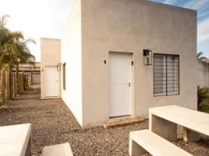a white building with two white doors and two benches at vivestadias in San Gregorio