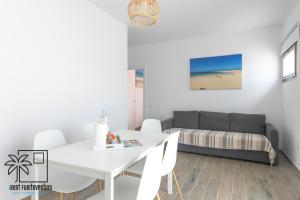 Una sala de estar con una mesa blanca y un sofá. en Lola Family Lajares iRent Fuerteventura, en La Oliva