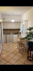 una cucina con armadi bianchi e un tavolo con una pianta in vaso di Le Mas des Amandiers a Saint-Paul-de-Vence