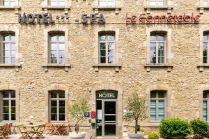 un grande edificio in mattoni con un cartello dell'hotel di Brit Hotel Spa Le Connetable a Dinan