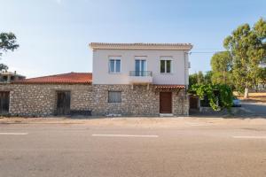 a brick house with a balcony on a street at Country House Pidasos in Pídhasos
