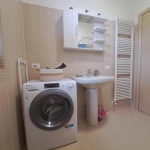 a bathroom with a washing machine and a sink at Alma Lake in Bellano