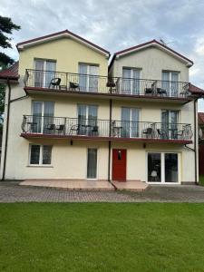 a large white house with a red door at Costa Mielno in Mielno