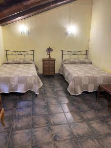 a bedroom with two beds and a wooden table at Casa Victoria in Hinojosa de Jarque