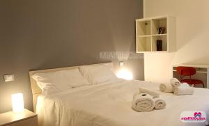 a bedroom with a white bed with towels on it at Bilocale Moka a Melzo vicino alla stazione e al centro in Melzo