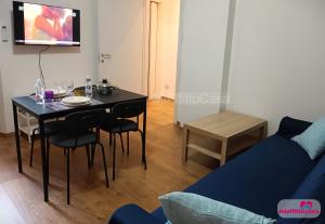 a living room with a table and a blue couch at Bilocale Moka a Melzo vicino alla stazione e al centro in Melzo