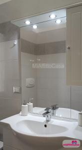 a bathroom with a white sink and a mirror at Bilocale Moka a Melzo vicino alla stazione e al centro in Melzo