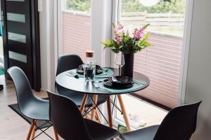 a table with chairs and a vase of flowers on it at Domek na Leśnej in Kęty