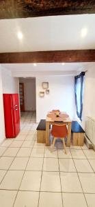 a dining room with a table and a red refrigerator at Appartement plein centre-ville in Lodève