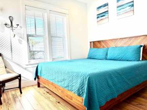 a bedroom with a bed with blue sheets and a window at Yellow Pearl Pool heat GolfCart deals Steps2Beach in Destin