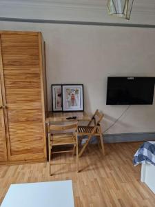 a living room with a table and a flat screen tv at Bright Studio Apartment in a perfect location in London
