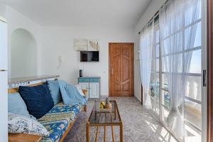 ein Wohnzimmer mit Couch und großem Fenster in der Unterkunft Sea View Apartment Blue Pearl in Arico