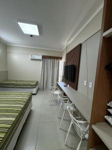 Una habitación con dos camas y un escritorio y sillas. en Borges Locaçoes, en Caldas Novas