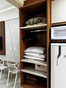 Una habitación con un armario con toallas y una nevera. en Borges Locaçoes, en Caldas Novas