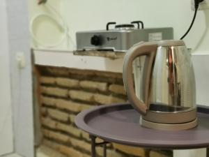a tea kettle on a table next to a toaster at Guest House Natia in Tbilisi City