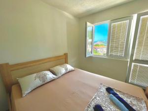 a bedroom with a bed with two windows at KAP Apartments in Sutomore