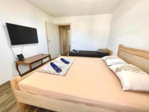 a bedroom with a large bed with a flat screen tv at KAP Apartments in Sutomore