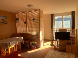 a living room with a television and a large window at Le Refuge de Lola & Bruno in Les Déserts