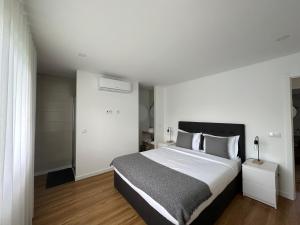a bedroom with a large bed with white walls at Ri&Vale Alojamentos in Vieira do Minho +49 photos