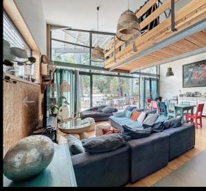 a living room with a large couch and a table at villa familiale cosy in Clermont-lʼHérault