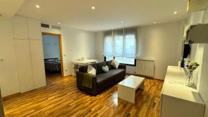 萨拉戈萨Suite Anna的客厅里有一张沙发和一张桌子。