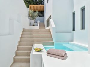 Villa Sol Alma Naousa Paros في ناوسا: وعاء من الفاكهة على طاولة بجانب بعض السلالم