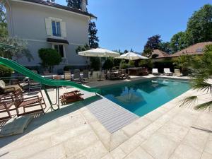 a swimming pool with a slide next to a building at Résidence MontBlanc duplex avec jacuzzi in Geneva