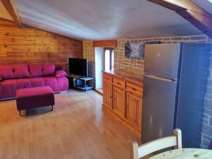 a living room with a red couch and a refrigerator at Le charme montagnard in Barcelonnette