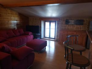 a living room with a red couch and chairs at Le charme montagnard in Barcelonnette