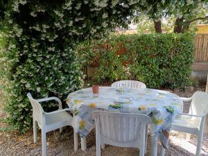 a table with three chairs and a tablecloth on it at CHEZ BETTY in Le Luc