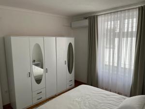 a white bedroom with a bed and a mirror at Sarajevo Luxury Apartment - 50 m from Old Sarajevo Clock Tower in Sarajevo