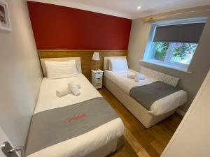 a small room with two beds and a window at Vauxhall Apartments in Norwich