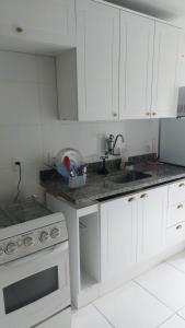 a kitchen with white cabinets and a sink at Ecoapê in Petrópolis