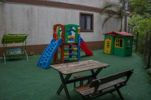 a playground with a table and a bench in a yard at Ecoapê in Petrópolis
