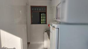 a kitchen with a white refrigerator and a window at Ecoapê in Petrópolis