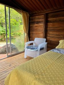 a bedroom with a bed and a chair and a window at Mirador del Padre in Gómez Plata +38 photos
