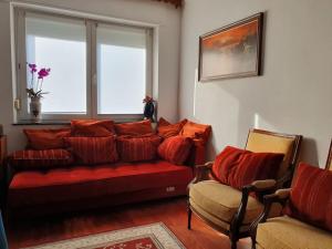 a living room with a red couch and a window at Le fourneau des pianistes in Nilvange