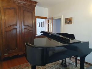 a black piano sitting in a living room at Le fourneau des pianistes in Nilvange