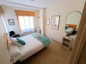 a small bedroom with a bed and a mirror at Feeling Home Lope de Fenar in León