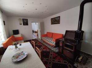 ein Wohnzimmer mit Kaminofen und Couch in der Unterkunft Cozy Room in the Old Town in Gjirokastër